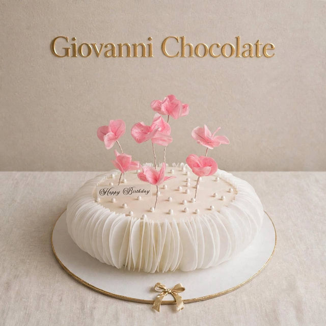 White cake with floating pink blossoms – Giovanni Chocolate UAE